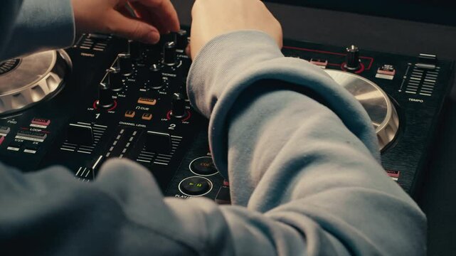 DJ playing music on festival in night club. Techno musician with headphones and sunglasses performing at nightclub for concert crowd of people, city bar.