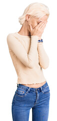 Young blonde woman wearing casual clothes with sad expression covering face with hands while crying. depression concept.