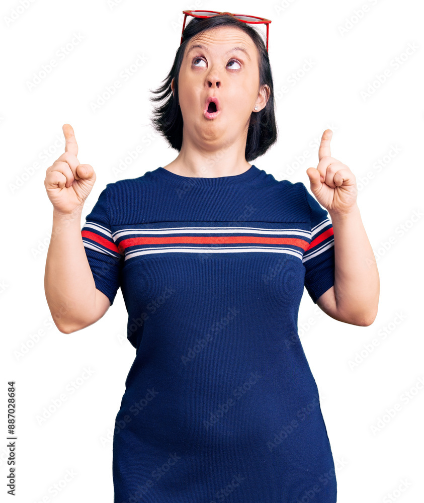 Poster brunette woman with down syndrome wearing casual clothes amazed and surprised looking up and pointin