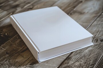 Fototapeta premium A white book sitting on top of a wooden table, perfect for use in education or office settings