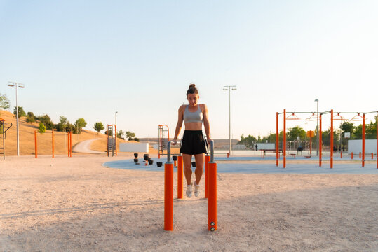 Young woman exercising at an outdoor park gym