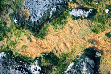 hot water flows from the crack in the colorful rock