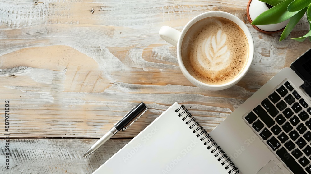 Wall mural work from home concept office desk setup with a laptop blank notepad coffee cup and pen on a wooden 