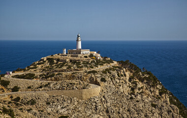 lighthouse on the rocky coastline in Mallorca with blue sky background