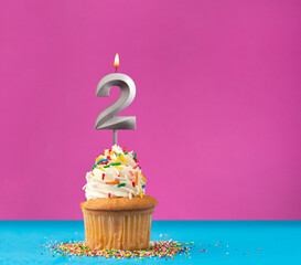 Cupcake with birthday candle number 2 - Anniversary card on blue and violet background