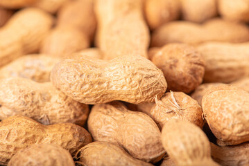 Peanuts, portion of peanuts in shell on a green and white checkered tablecloth. Selective focus.