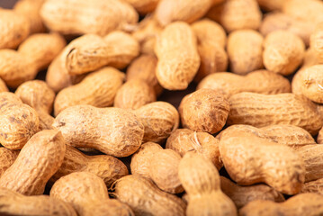 Peanuts, portion of peanuts in shell on a green and white checkered tablecloth. Selective focus.