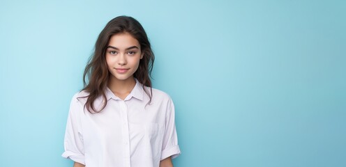 Fototapeta premium A woman with long hair is wearing a white shirt and smiling