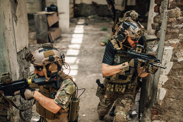 Group of air soft soldiers going in a battle in ruined building.