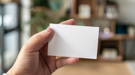 person holding a white card mockup in an office