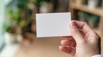 person holding a white card mockup in an office