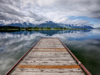 Landscape photo of dock on calm water.