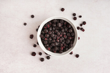 Bowl of freeze-dried black currant on light background