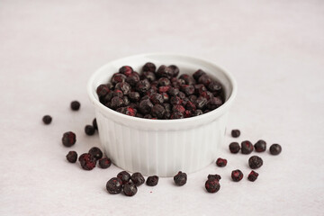 Bowl of freeze-dried black currant on light background