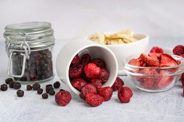 Bowls with different freeze-dried fruits on light background