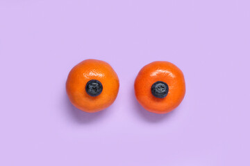 Ripe tangerines with blueberries on color background. Erotic and female health care concept