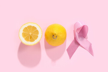 Halves of fresh lemon with piercing and pink ribbon on color background. Breast cancer awareness...