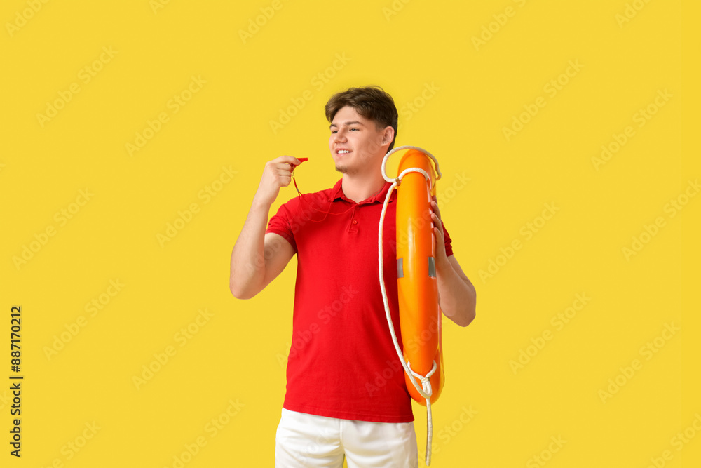 Wall mural male lifeguard with whistle and ring buoy on yellow background