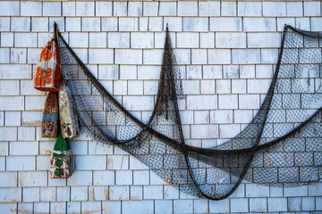 fishing net and weathered floats hanging on a wooden shingled wall room for text shot peggy's cove nova scotia © Michael Connor Photo