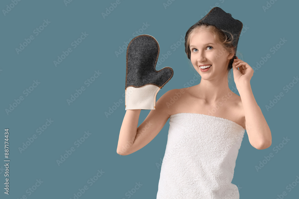 Canvas Prints Young woman in sauna hat with massage glove on blue background