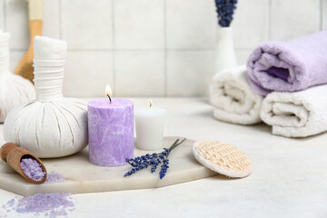 Beautiful composition with lavender sea salt, herbal bag and candle on tile background, closeup