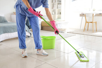 Janitor mopping floor in dorm room, closeup