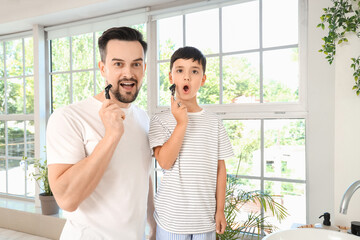 Shocked father and his little son with razors in bathroom