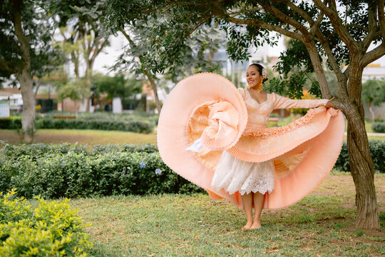Dancer wearing colorful dress performing peruvian marinera in the park