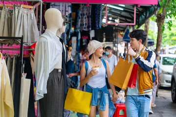 Happy Asian man and woman couple enjoy and fun outdoor lifestyle travel in the city shopping and...