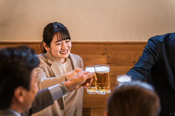 居酒屋・飲み屋で乾杯する男女のサラリーマン
