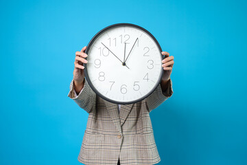 Clock Face Of Businesswoman Showing And Holding Clock Isolated On Blue Background