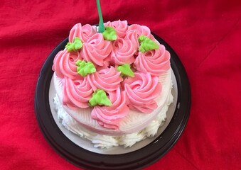 Happy birthday cake white creamy pink flowers cream green leaves on top 