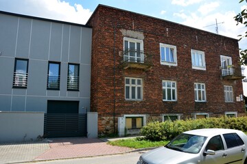 A new residential building near an old, over 100-year-old red brick tenement house