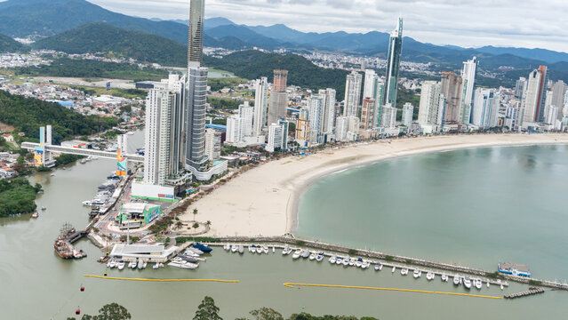 beachfront in Balne&aacute;rio Cambori&uacute;, Santa Catarina, Brazil, seen from above, beach and large building in the background.
