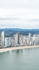 Fototapeta premium beachfront in Balneário Camboriú, Santa Catarina, Brazil, seen from above, beach and large building in the background.