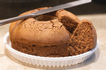 Bolo de chocolate faltando uma fatia. Uma faca sobre o bolo na composição.