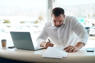 Man, contract and writing in office at car dealership with deal, sales or discount for vehicle....
