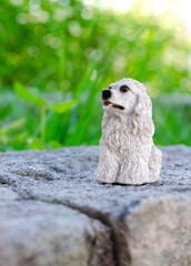 Figura realista de perro cocker spaniel adiestrado y sentado en el parque con pelaje blanco 