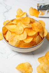 Potato chips in a bowl on a light background