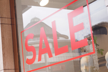 Large red Sale text letters on a glass wall obstruct a view inside the popular fashion store