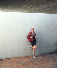 Education, thinking and student with a woman punk leaning against a gray wall on the campus of her university. Gen z, idea and scholarship with a young female pupil standing at college for learning