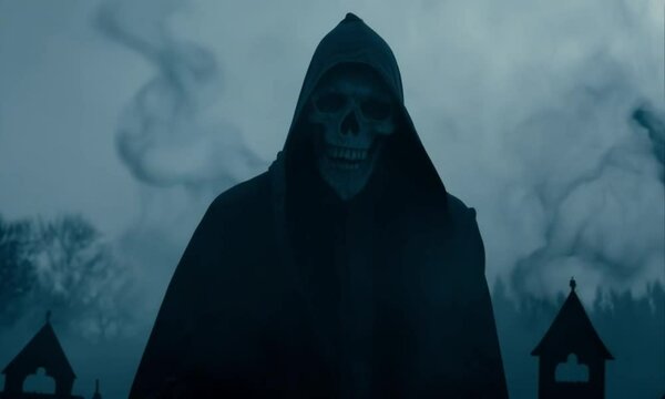 A grim reaper figure in a dark cloak and hood, with a skeletal face, stands in a foggy, eerie landscape, evoking a sense of death and horror under a full moon.