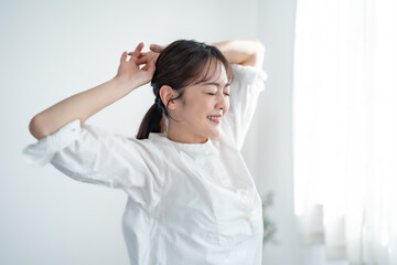 部屋で伸びをする女性