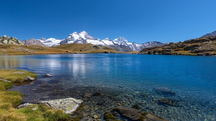 A serene lake surrounded by snow-capped mountains under a clear sky