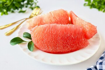 Grapefruit Ruby of Siam,Siam ruby ​​grapefruit,  tabtimsiam pomelo, red pomelo, in white plate on white table background, 