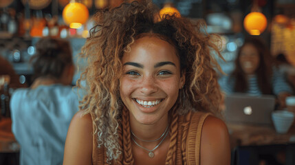 Diverse group of young professionals collaborating and smiling in a cafe, working on laptops and setting business goals