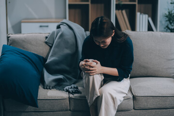 Fototapeta premium A woman with a cold with pills is treated at home chooses which drugs to take and self-medicates, checks the expiration date while sitting on the couch at home