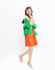 Young Asian woman exudes happiness, displaying a joyful expression as she stands against a white background.