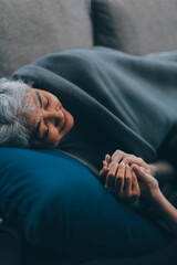 happy family Granddaughter takes care of her grandmother with warm cloths sitting on the sofa.