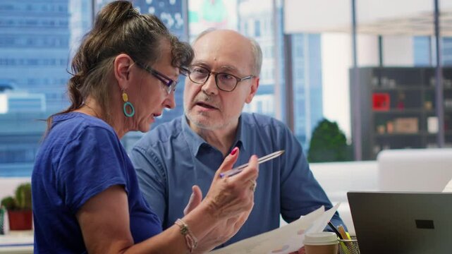 Mature couple receiving tailored financial advice on retirement planning, focusing on maximizing savings, investment growth and long term financial security. Clients plan pension funds. Camera A.